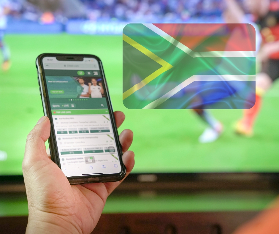 Hand with Phone and South African Flag Against TV